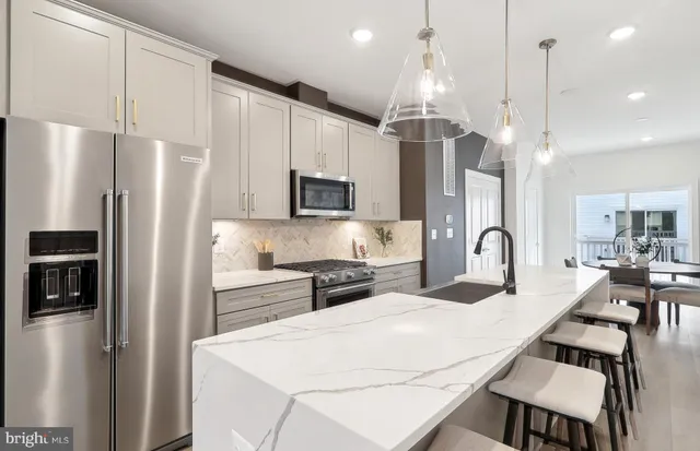 a kitchen with stainless steel appliances a refrigerator sink and microwave