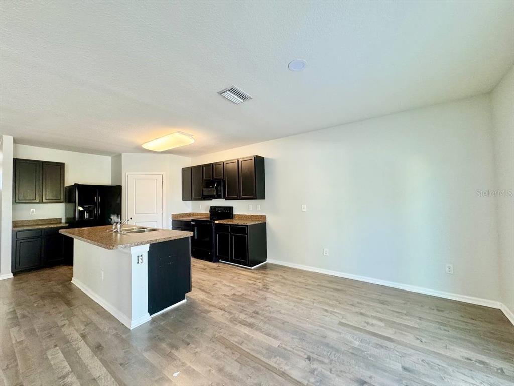 35743 Hillbrook Avenue Zephyrhills, FL 33541 - Photo 12 of 44 a living room with furniture a flat screen tv and kitchen view
