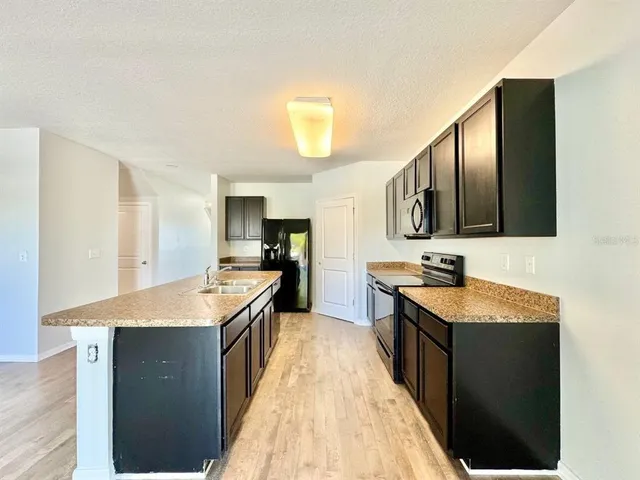 a kitchen with granite countertop a sink and a stove