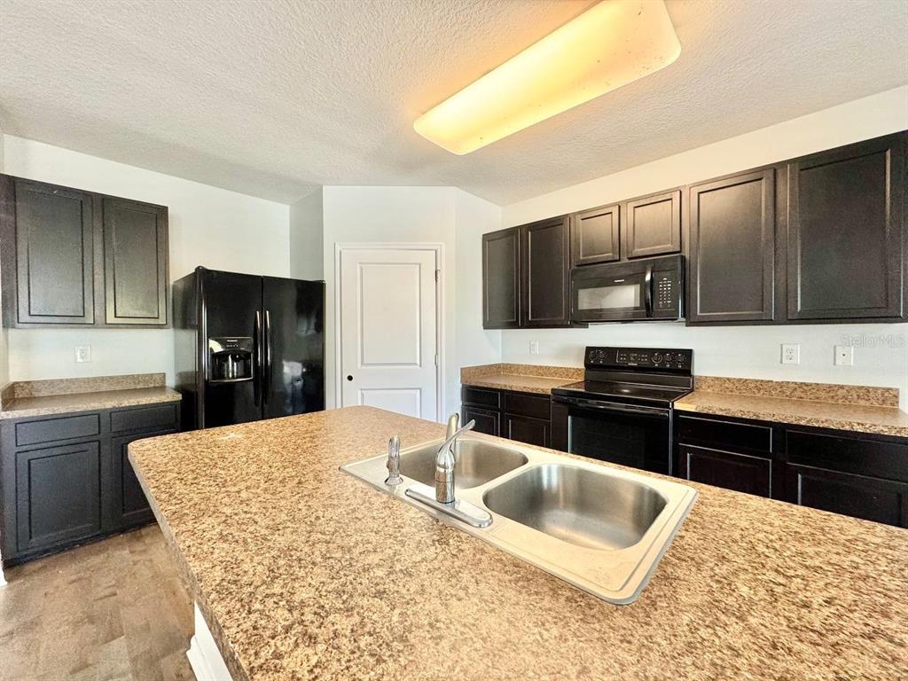 35743 Hillbrook Avenue Zephyrhills, FL 33541 - Photo 14 of 44 a kitchen with stainless steel appliances kitchen island granite countertop a sink dishwasher stove and refrigerator
