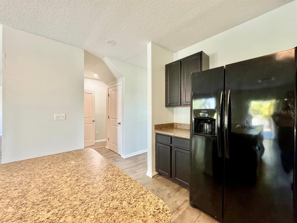 35743 Hillbrook Avenue Zephyrhills, FL 33541 - Photo 17 of 44 a kitchen with stainless steel appliances kitchen island granite countertop a refrigerator and a sink