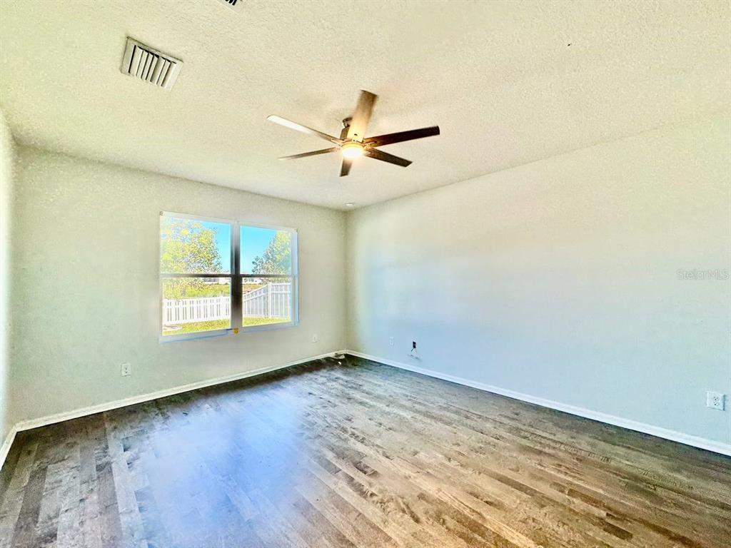 35743 Hillbrook Avenue Zephyrhills, FL 33541 - Photo 19 of 44 an empty room with wooden floor and windows