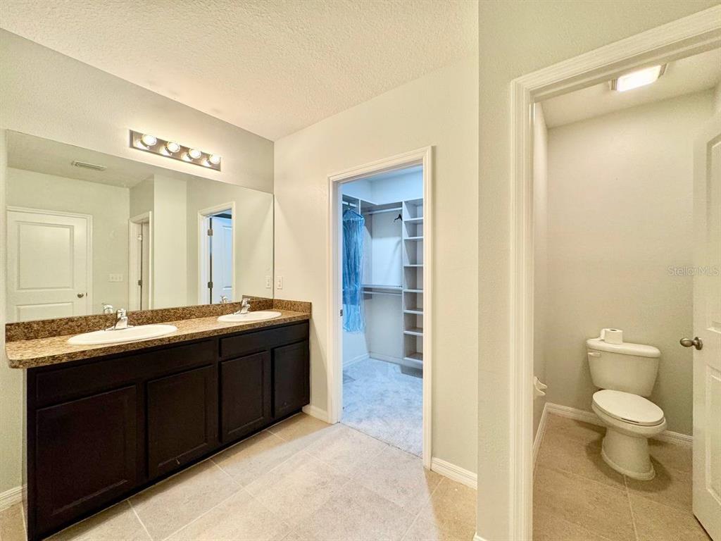 35743 Hillbrook Avenue Zephyrhills, FL 33541 - Photo 22 of 44 a spacious bathroom with a double vanity sink toilet mirror and a shower