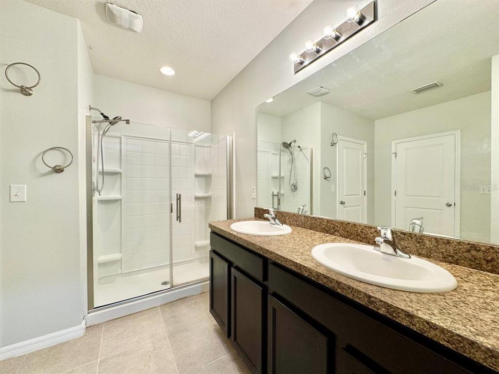 35743 Hillbrook Avenue Zephyrhills, FL 33541 - Photo 23 of 44 a bathroom with a granite countertop sink a shower a mirror and a bathtub