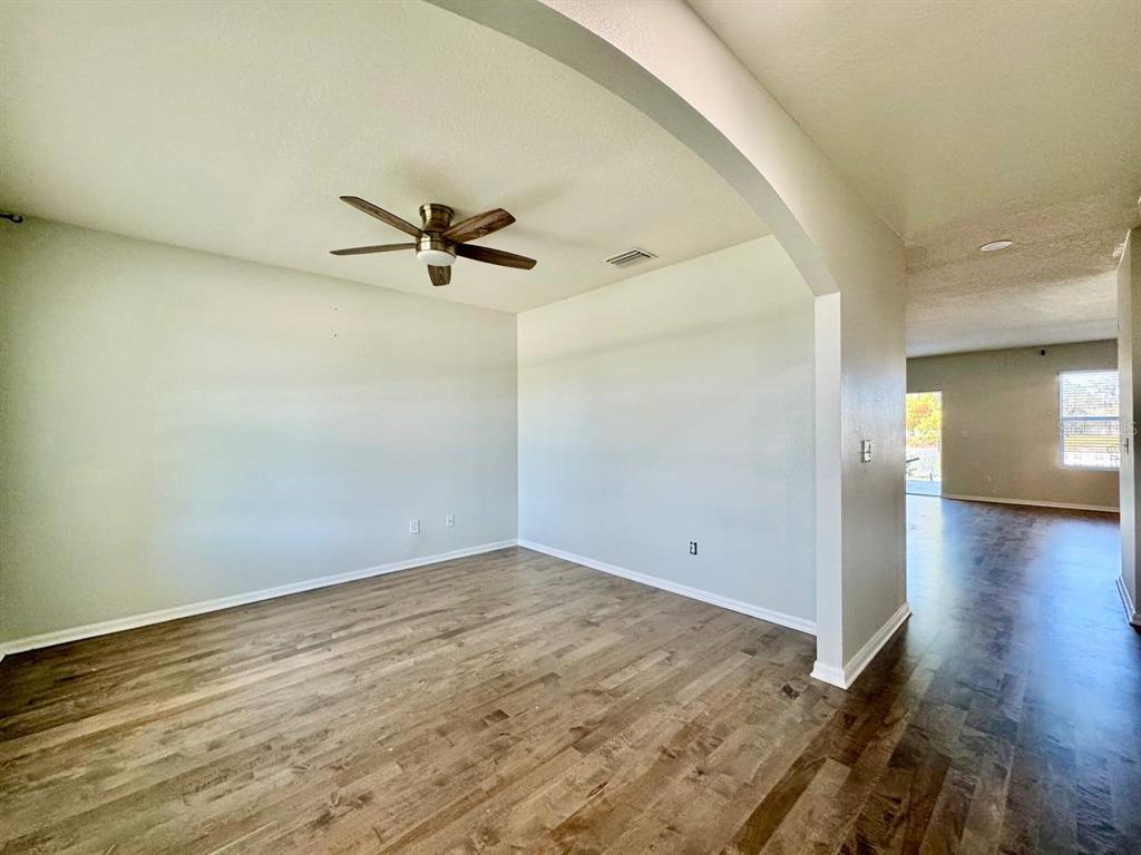 35743 Hillbrook Avenue Zephyrhills, FL 33541 - Photo 5 of 44 wooden floor in an empty room with a window