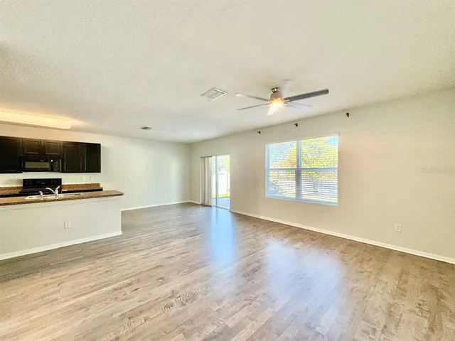 a view of kitchen with wooden floor and electronic appliances