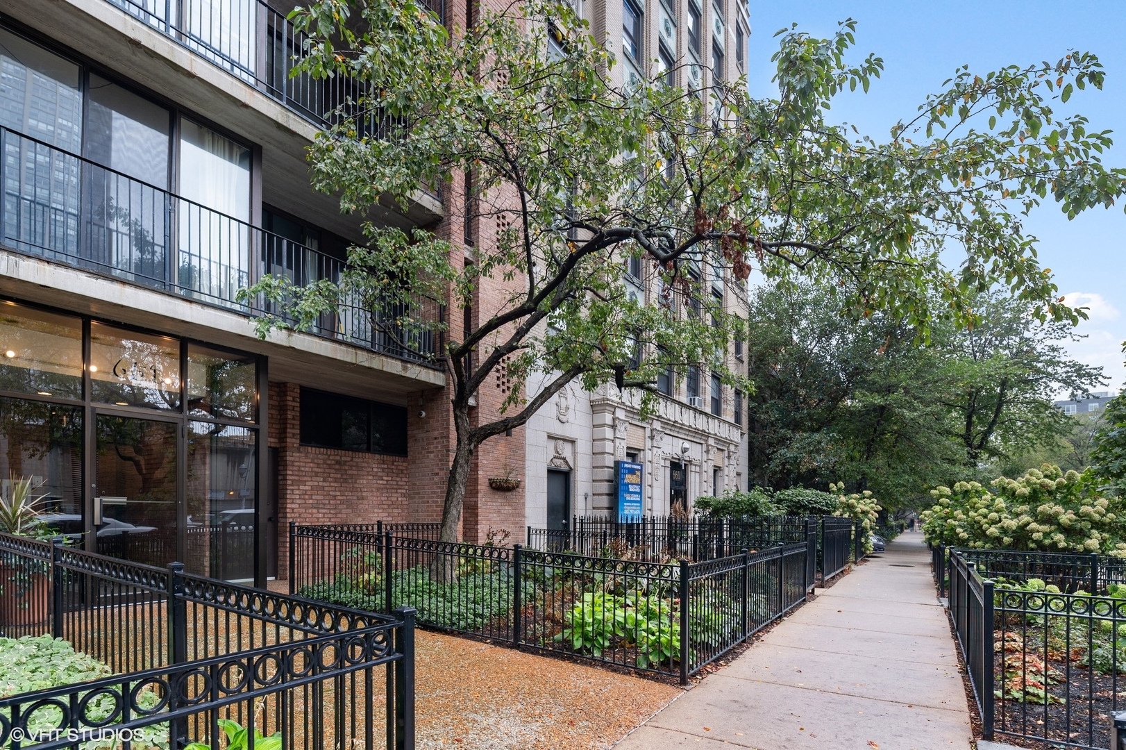 651 West Sheridan Road, Unit 2C Chicago, IL 60613 - Photo 2 of 16 a view of a white house with large windows and a small yard