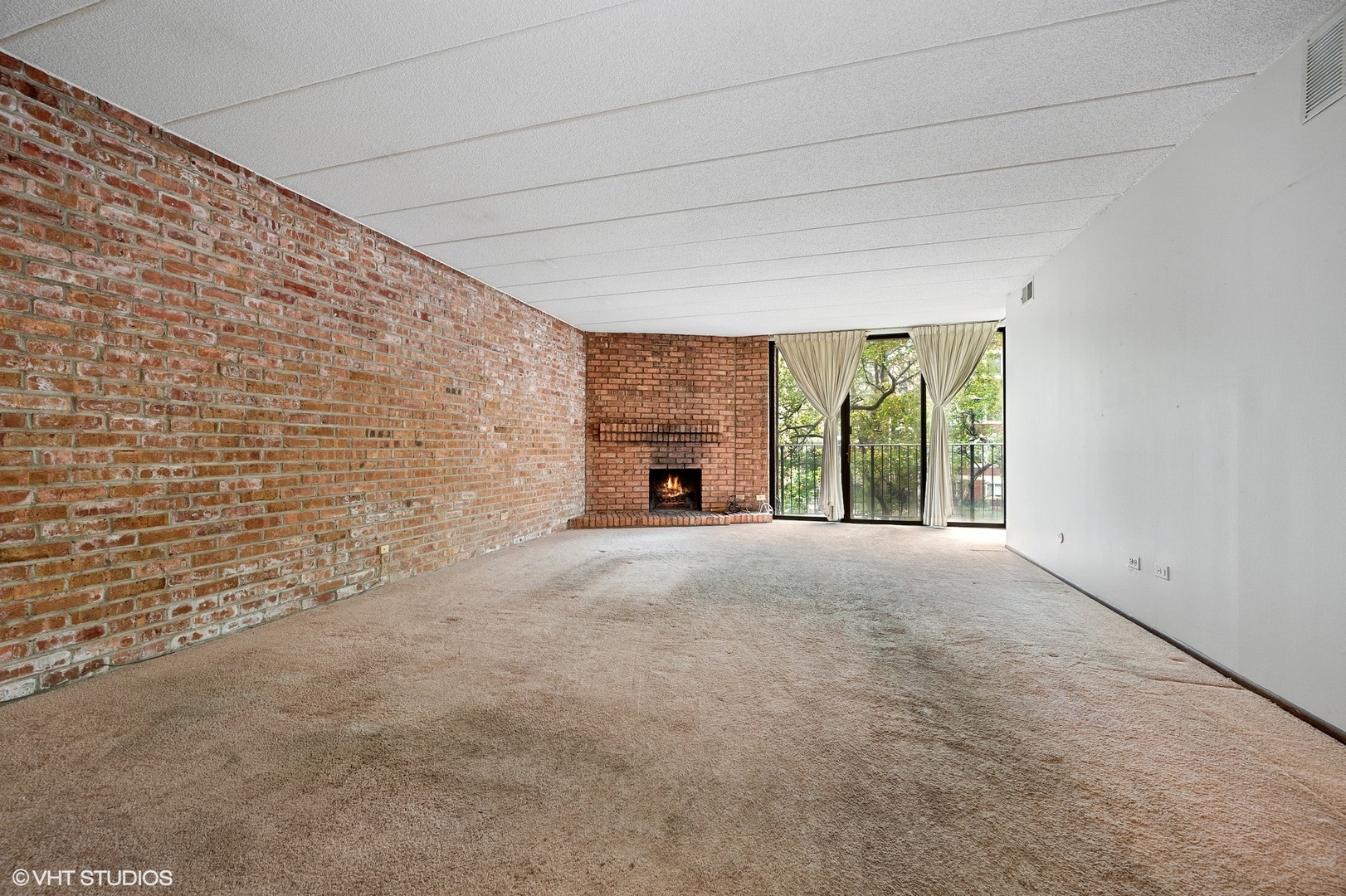 651 West Sheridan Road, Unit 2C Chicago, IL 60613 - Photo 4 of 16 a view of an empty room with a fireplace and a window