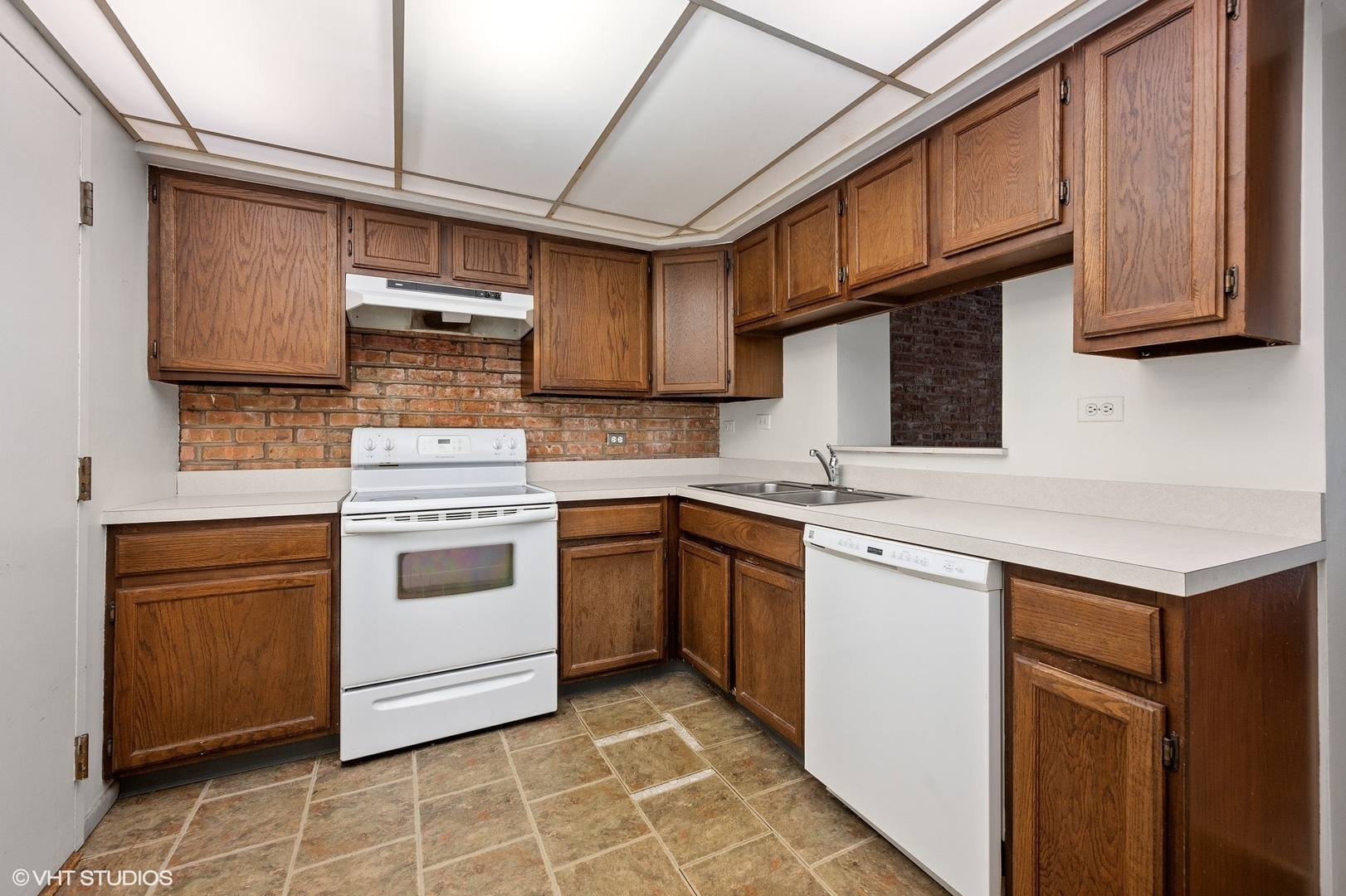 651 West Sheridan Road, Unit 2C Chicago, IL 60613 - Photo 5 of 16 a kitchen with stainless steel appliances granite countertop a sink a stove a refrigerator cabinets and a microwave oven