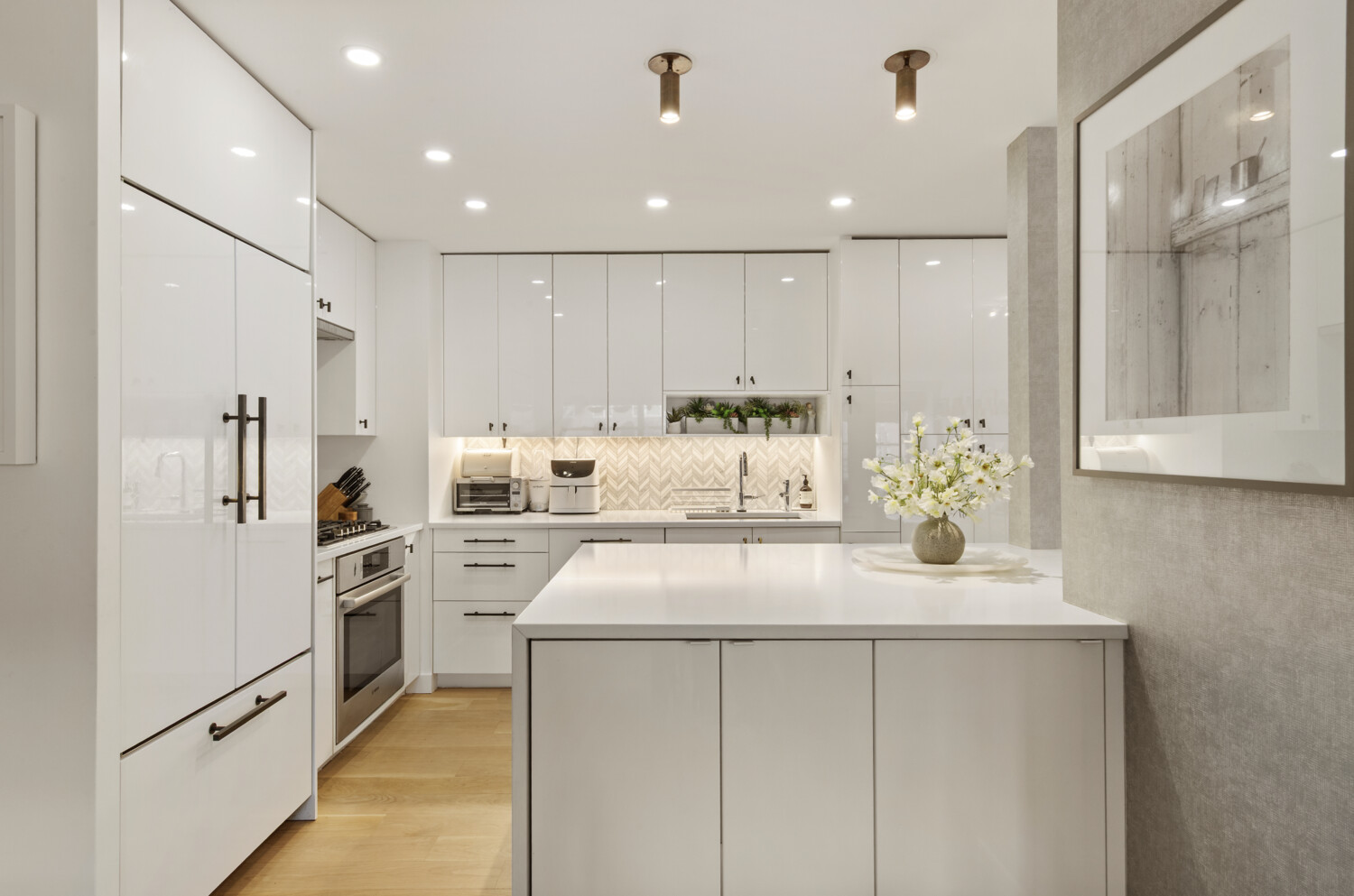 300 East 71st Street, Unit 16HJ Manhattan, NY 10021 - Photo 2 of 8 a kitchen with white cabinets and stainless steel appliances