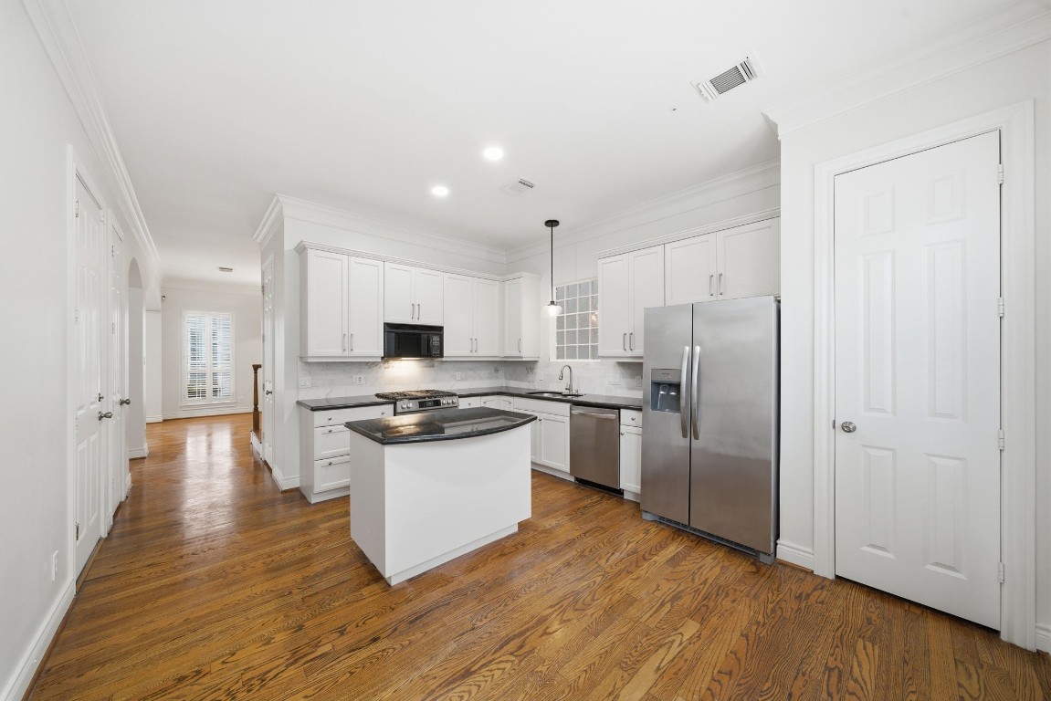 1736 Colquitt Street, Unit A Houston, TX 77098 - Photo 14 of 45 a kitchen with stainless steel appliances a refrigerator and a stove top oven