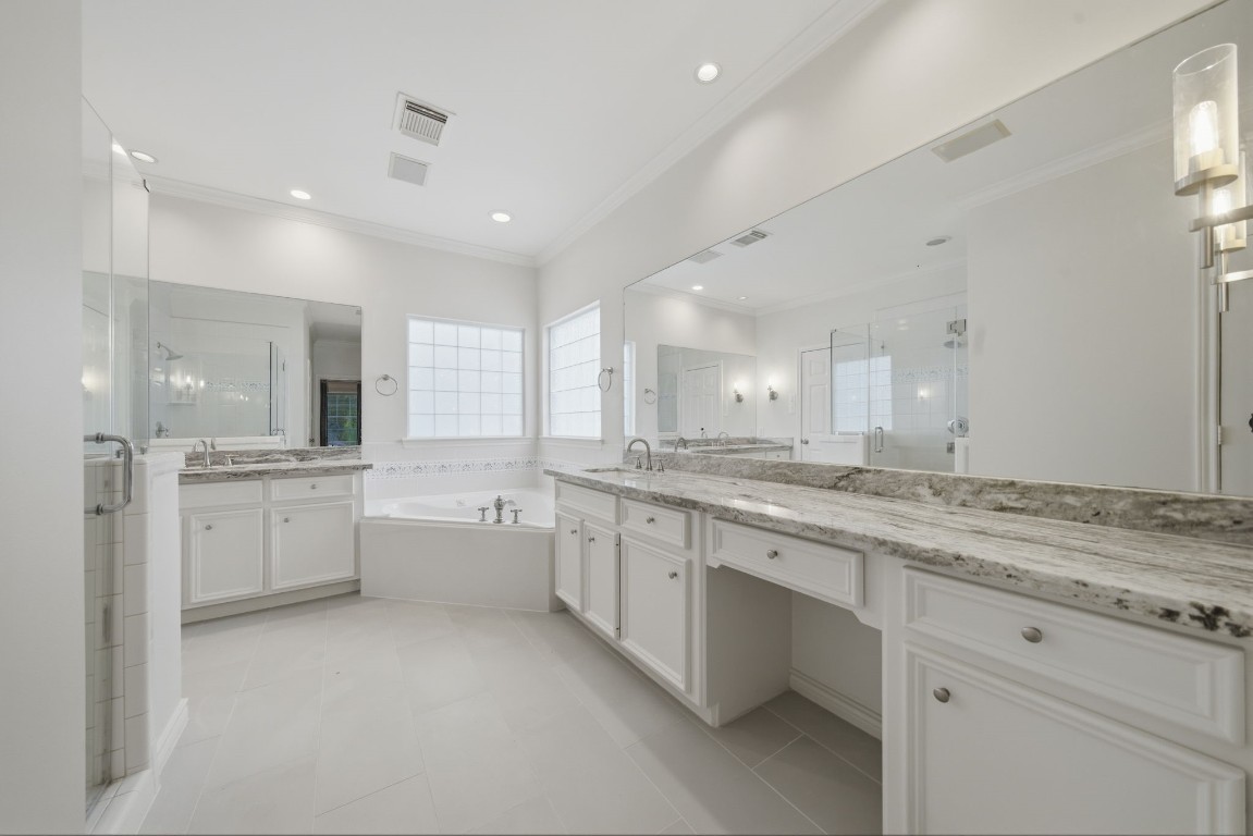 1736 Colquitt Street, Unit A Houston, TX 77098 - Photo 33 of 45 Offering dual vanities, two closets, and a jetted tub, the spacious primary bath has been refreshed with new tile, sconce lighting, granite countertops, and sleek fixtures for a clean, modern feel.