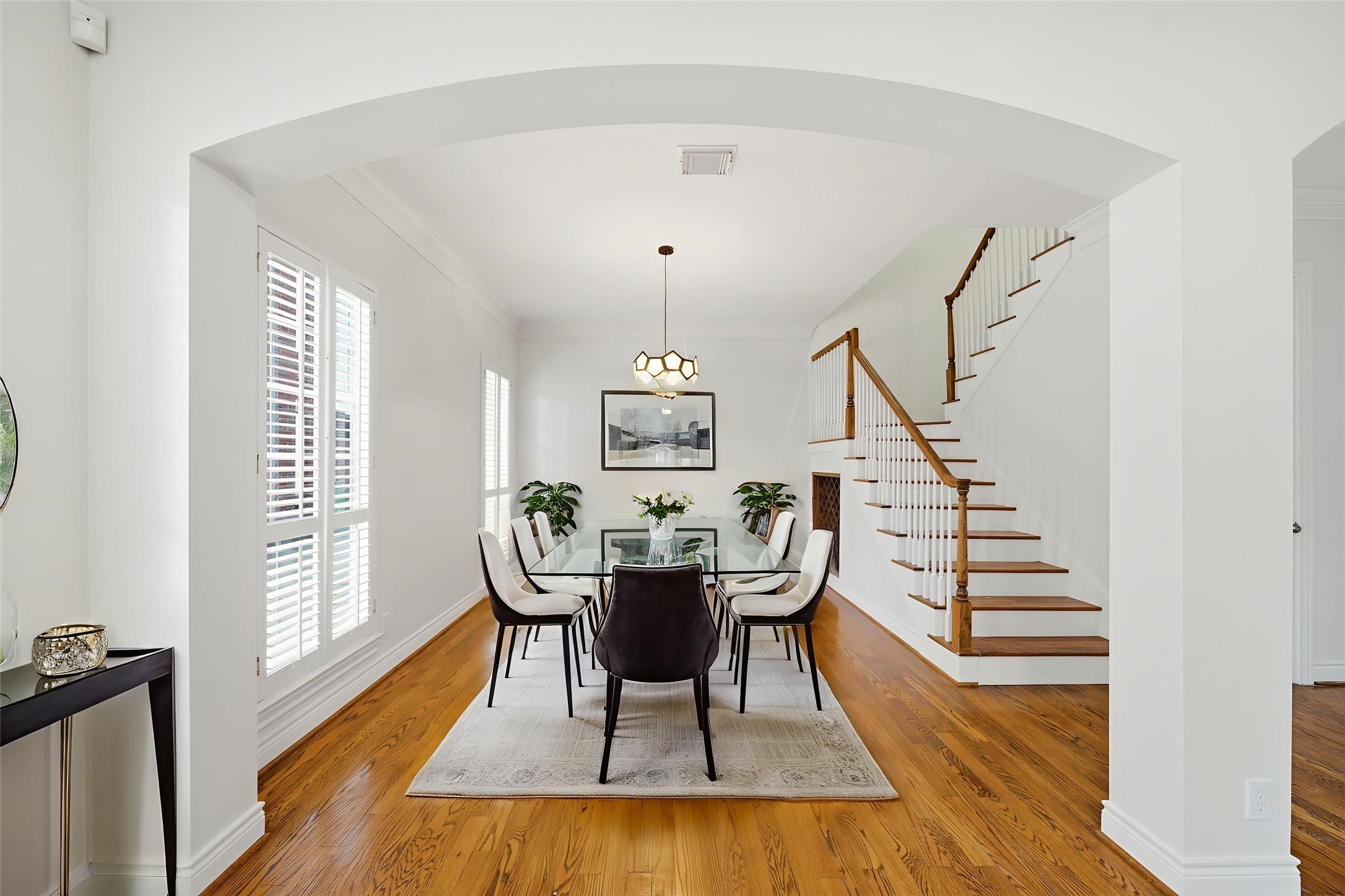 1736 Colquitt Street, Unit A Houston, TX 77098 - Photo 6 of 45 The archway frames a dedicated dining area filled with natural light and plantation shutters, all connected by an open layout ideal for hosting. - Virtually Staged -