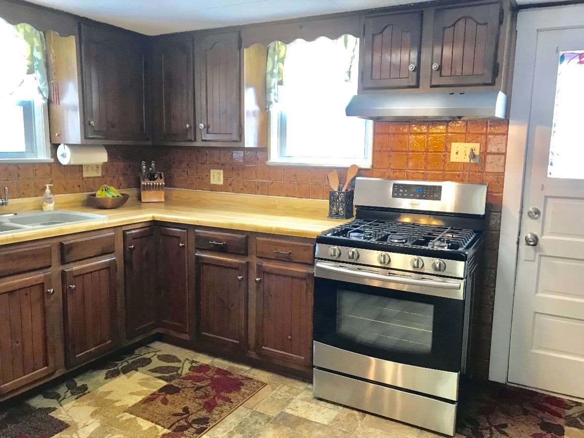 216 South Washington Street Byron, IL 61010 - Photo 14 of 25 a kitchen with a stove sink and cabinets