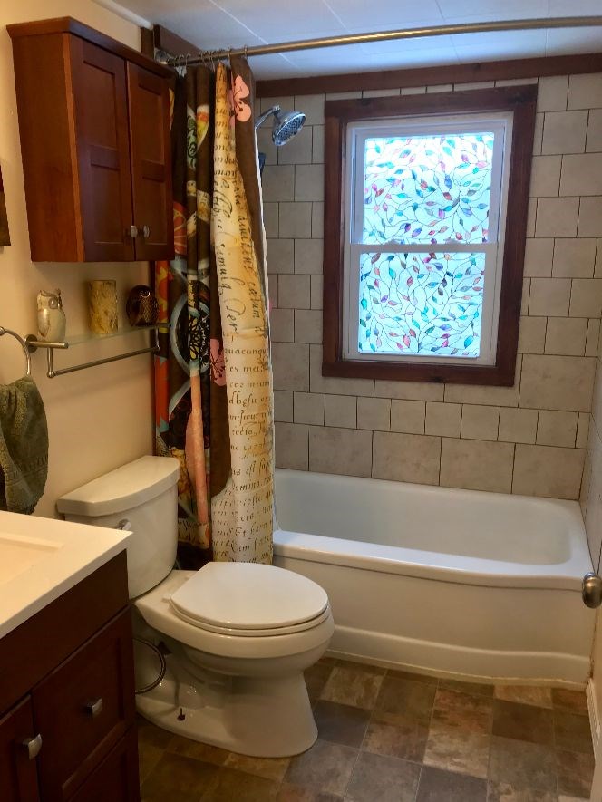 216 South Washington Street Byron, IL 61010 - Photo 21 of 25 a bathroom with a toilet a sink and bathtub