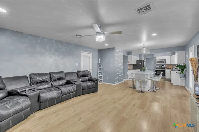 a living room with furniture and view of kitchen