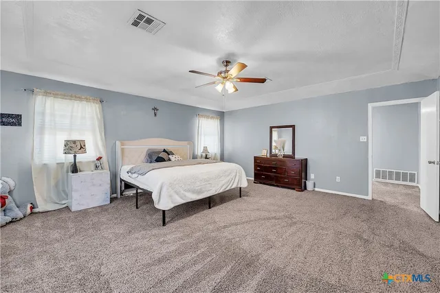 a spacious bedroom with a bed and window