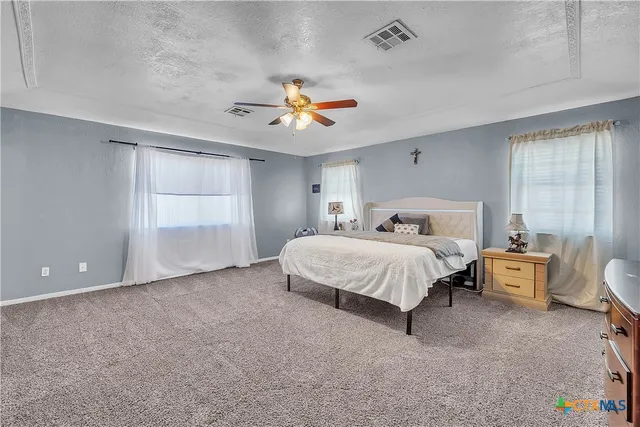 a spacious bedroom with a bed and a window