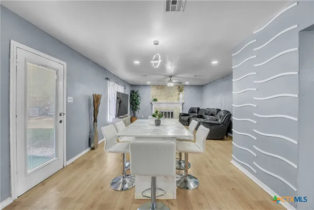 a view of a dining room with furniture a chandelier and wooden floor