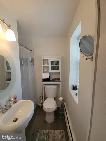 a bathroom with a toilet sink and mirror