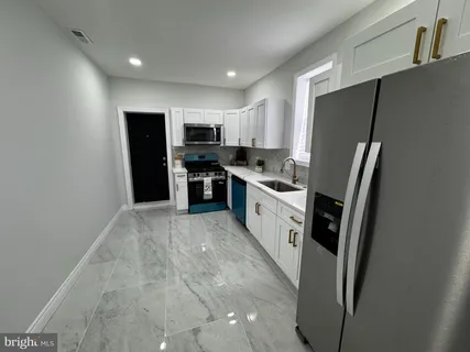 a kitchen with stainless steel appliances granite countertop a refrigerator a stove a sink and a refrigerator