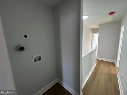 a view of a hallway with wooden floor and closet