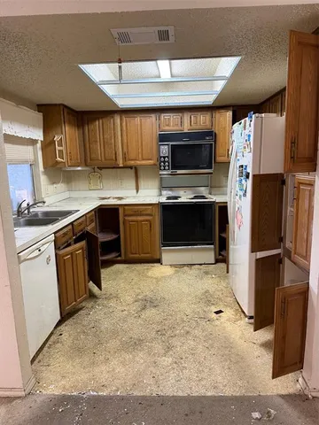 a kitchen with stainless steel appliances granite countertop a stove refrigerator sink and cabinets