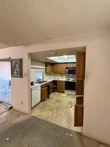 a view of kitchen with kitchen island a sink wooden floor and stove