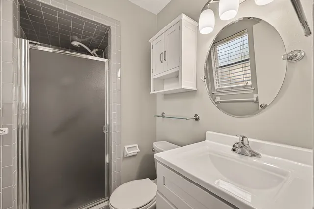 a bathroom with a sink a toilet and shower