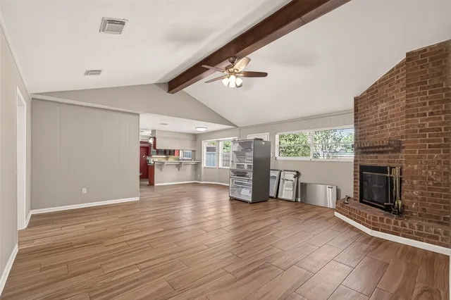 a view of empty room with wooden floor and fireplace