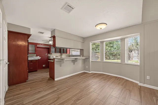 a kitchen with a refrigerator and wooden floor