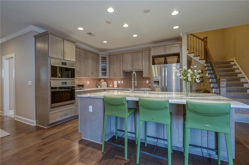 116 Seneca Place Mars, PA 16046 - Photo 8 of 25 a kitchen with kitchen island granite countertop a table chairs microwave and refrigerator