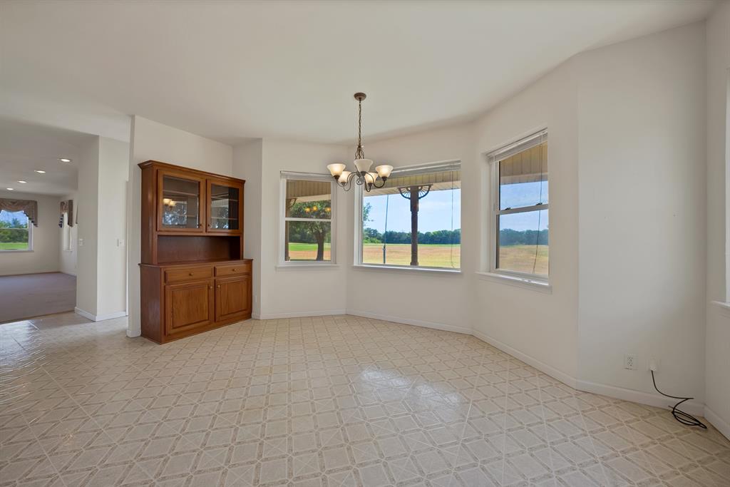 12748 County Road 4077 Scurry, TX 75158 - Photo 21 of 40 an empty room with chandelier and windows