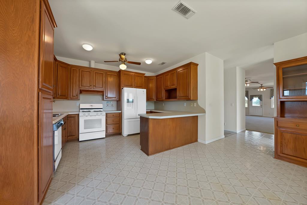 12748 County Road 4077 Scurry, TX 75158 - Photo 40 of 40 a kitchen with stainless steel appliances a refrigerator and a stove top oven