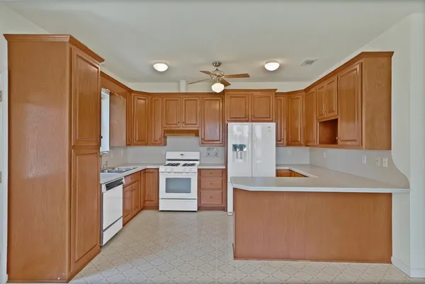 a kitchen with stainless steel appliances granite countertop a refrigerator a stove and a sink