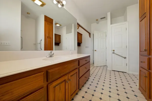 a bathroom with a double vanity sink toilet and shower