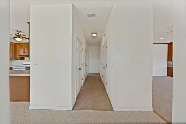 a view of a hallway with wooden floor and closet