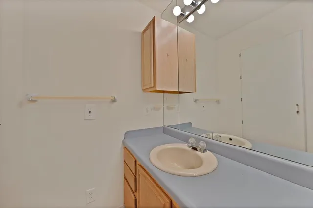 a bathroom with a granite countertop sink and a mirror