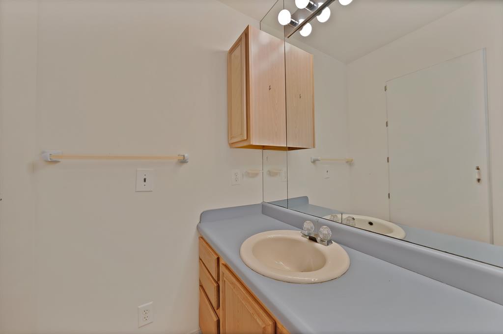 12748 County Road 4077 Scurry, TX 75158 - Photo 38 of 40 a bathroom with a granite countertop sink and a mirror