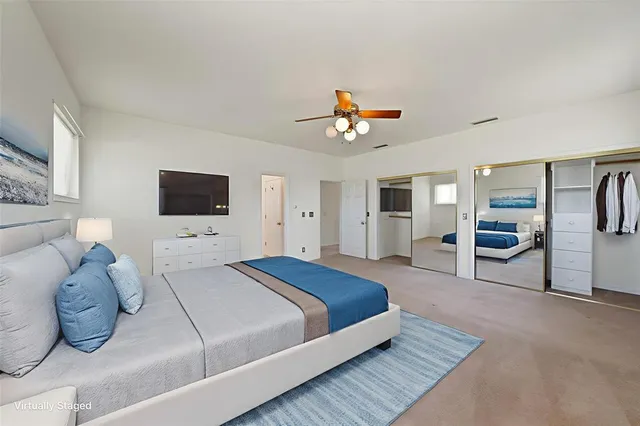 a spacious bedroom with a bed and a flat screen tv