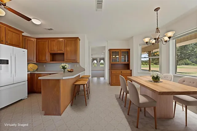 a kitchen that has a table chairs and refrigerator