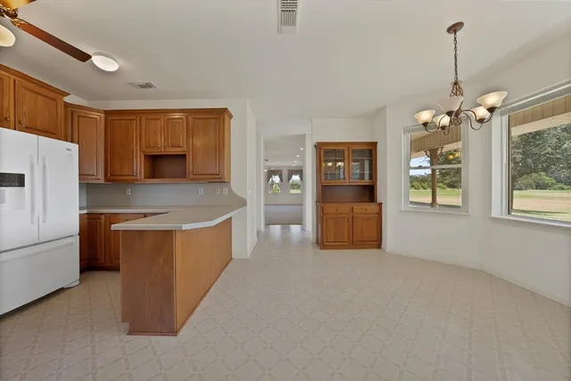 a large kitchen with stainless steel appliances granite countertop a refrigerator and a stove top oven