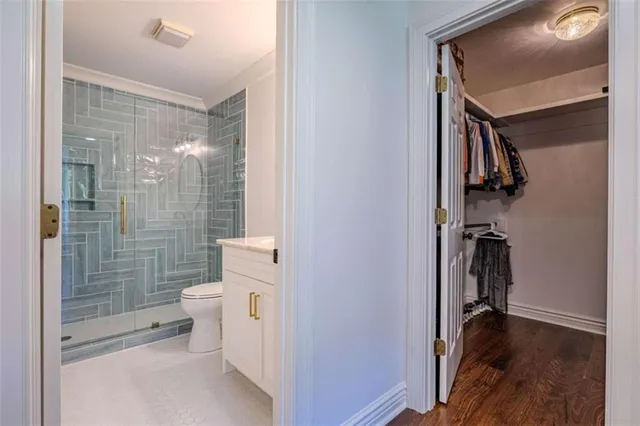 a bathroom with a granite countertop sink a toilet and a mirror