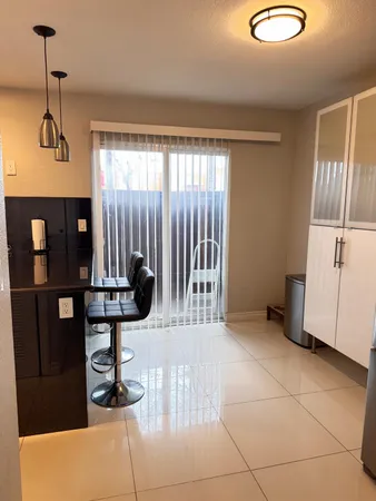a kitchen with a sink a counter and a view of living room
