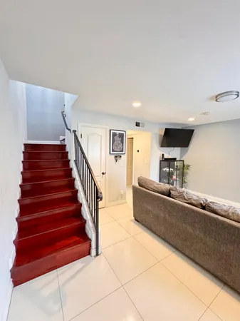 a living room with furniture and stairs