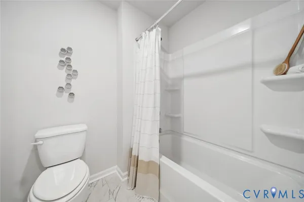 a white toilet sitting next to a bath tub