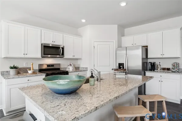 a kitchen with granite countertop a sink a counter top space appliances and cabinets
