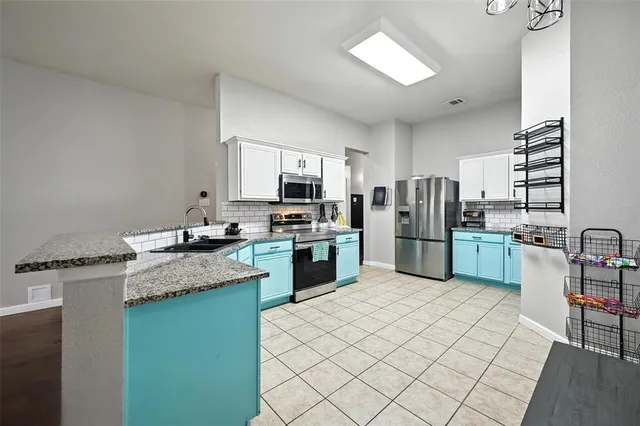 a kitchen with stainless steel appliances granite countertop a sink dishwasher stove top oven and refrigerator