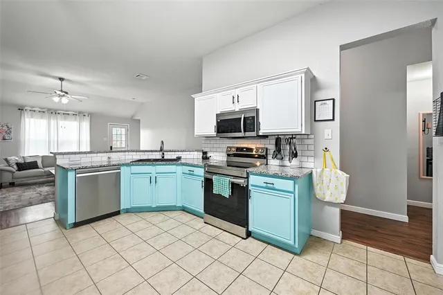 a kitchen with stainless steel appliances granite countertop a refrigerator and a stove top oven