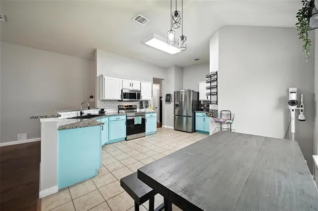 a kitchen with stainless steel appliances granite countertop a refrigerator a stove top oven a sink dishwasher and wooden cabinets